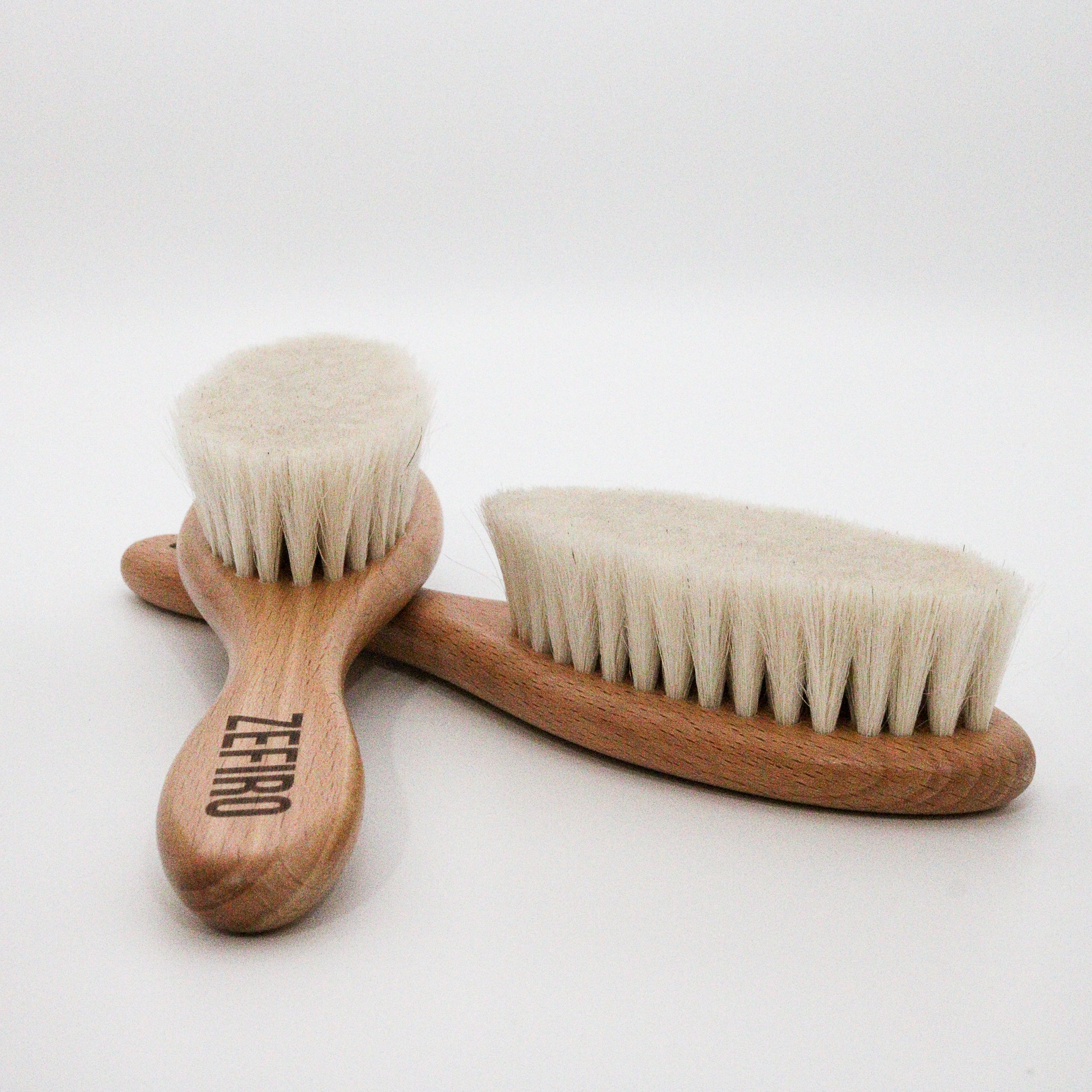 Two wooden baby fine hair brushes with natural bristles on a white background